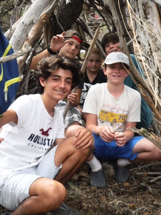 Campers learning fire and wilderness skills in a circle